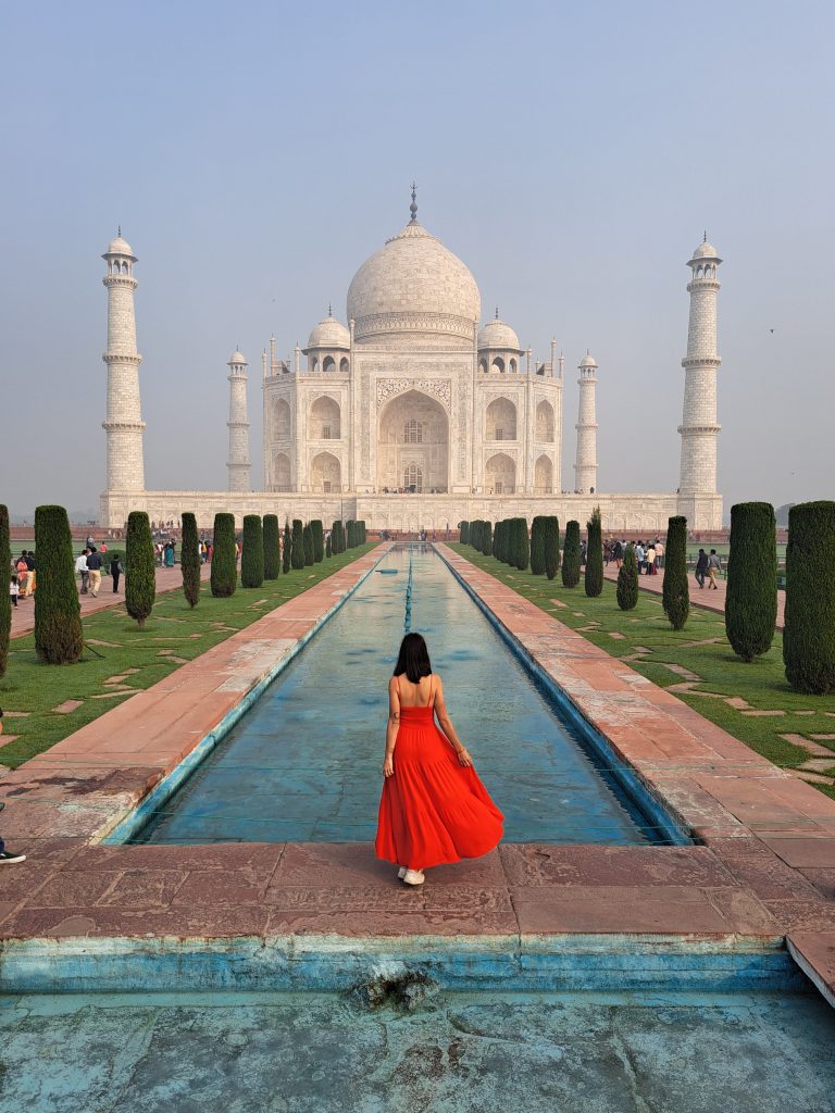 Taj mahal desde los jardines con chica vestido rojo