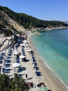 playa de albania con muchas sombrillas y agua turquesa